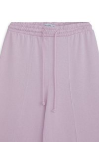 Helle pinke Jogginghosen mit einem elastischen Bund, Kordelzug und Seitennähten. Hergestellt aus einem weichen Stoff, der für Freizeitkleidung geeignet ist.