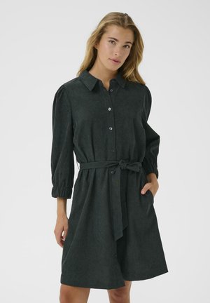 Robe chemise vert foncé en tissu texturé. Présente un devant à boutons, un col, des manches bouffantes trois-quarts et une ceinture à nouer à la taille.