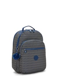 Mochila a cuadros azul y beige con bolsillo frontal con cremallera y pequeño llavero de mono de peluche colgando al lado.