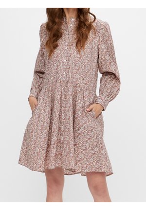 Robe fleurie en tissu doux, manches longues, design plissé et poches latérales. Principalement rose avec des motifs floraux blancs et verts.