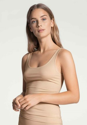 Beige tanktop met dunne bandjes, gemaakt van een gladde, rekbare stof. Heeft een aansluitende silhouet en een ronde halslijn.
