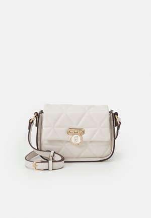 Pequeño bolso bandolera blanco acolchado con cierre circular dorado y correa ajustable sobre fondo liso.