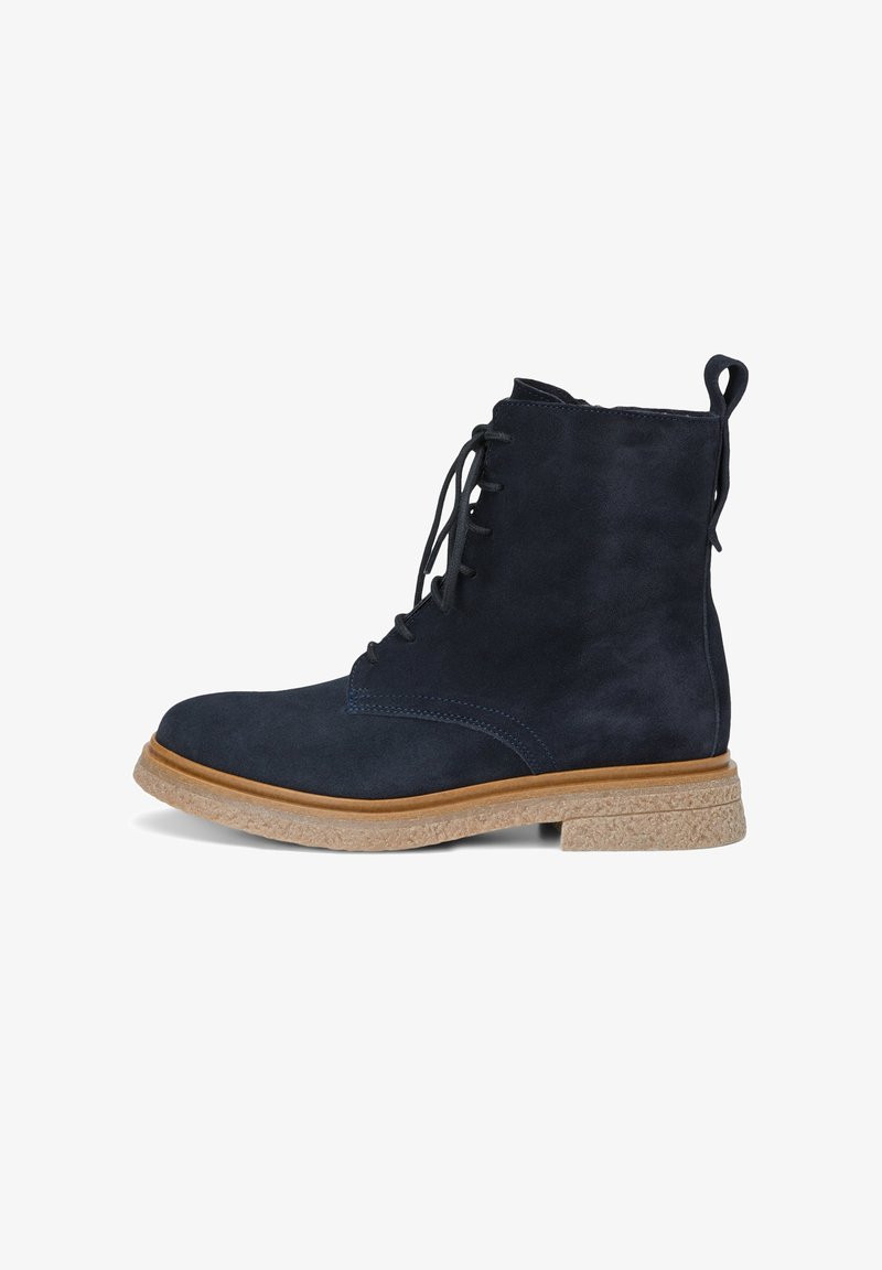 Bottine montante en daim bleu marine à lacets, avec une semelle en caoutchouc brun clair et une languette à l'arrière, présentée de profil à gauche.