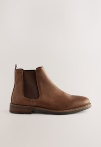 Botte Chelsea en cuir marron avec panneaux latéraux élastiques, bout rond, coutures minimales et petit talon empilé. Texture lisse et design classique.