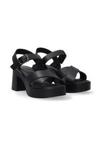 Schwarze High Heels Sandalen mit einem klobigen Blockabsatz, mehreren überkreuzten Riemen, verstellbarem Knöchelriemen und glatter, matter Oberfläche.