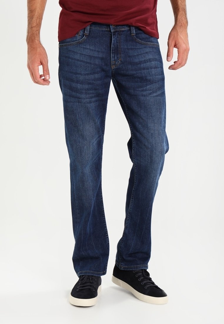 Blå denimjeans med rak passform, urtvättad textur, femfickorsdesign och spänne, tillsammans med svarta sneakers.