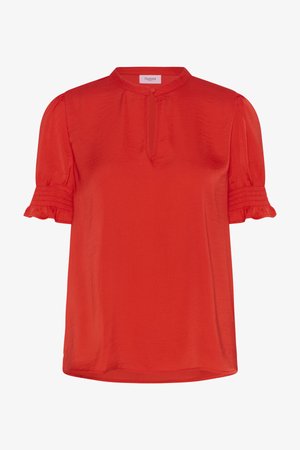 Piros, rövid ujjú blúz álló gallérral, kulcslyuk kivágással és fodros ujjak végével. Könnyű, sima anyagból készült.