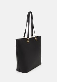 Black tote bag made of smooth, matte material. Features two long handles, gold-tone hardware, and a structured rectangular shape.