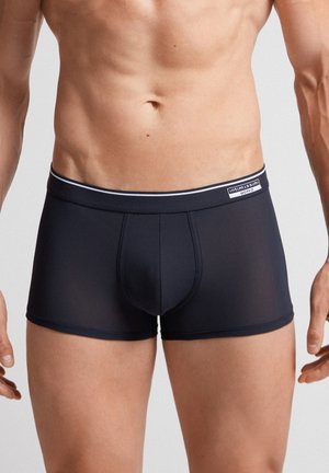 Dunkelblaue trunkartigen Unterwäsche mit einem weichen, elastischen Bund, der einen weißen Streifen und ein Logoetikett bietet. Glattes, dehnbares Material, taillierte Passform.