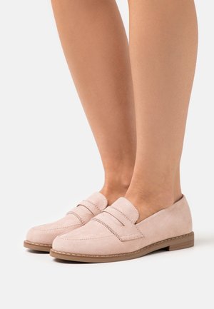 Mocassins en daim rose avec accents de couture doubles, semelle plate et petit talon. Bout rond et design minimaliste sans quincaillerie visible.