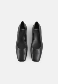 Černé kožené lodičky s hranatou špičkou. Hladká textura a nazouvací styl, s minimalistickým vzhledem bez viditelného kovového zdobení.