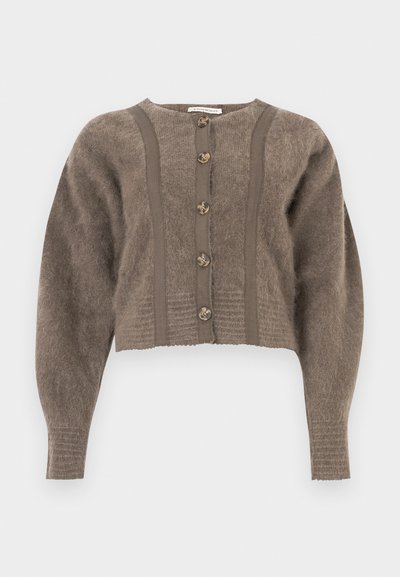 Cardigan maro scurt, pufos, cu mâneci lungi, cinci nasturi de tip scoică și detalii verticale din tricot.