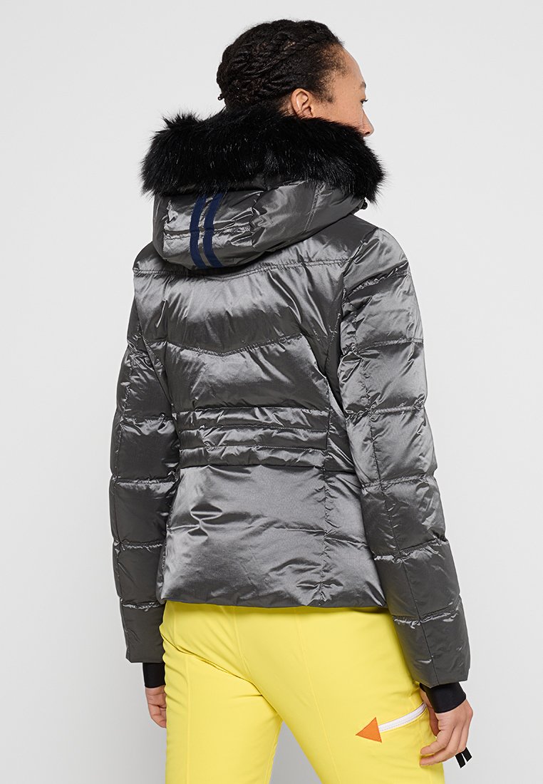Chaqueta gris acolchada con capucha de pelo, que cuenta con cremallera y rayas en color marino en la parte posterior, tejido texturizado y forma ajustada.