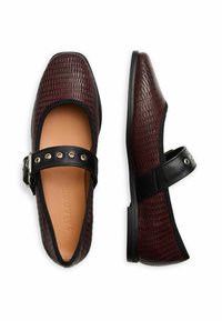 Bailarinas burdeos con estampado de cocodrilo, cinta y hebilla negras, punta redondeada, interior en suave cuero y suela negra baja.