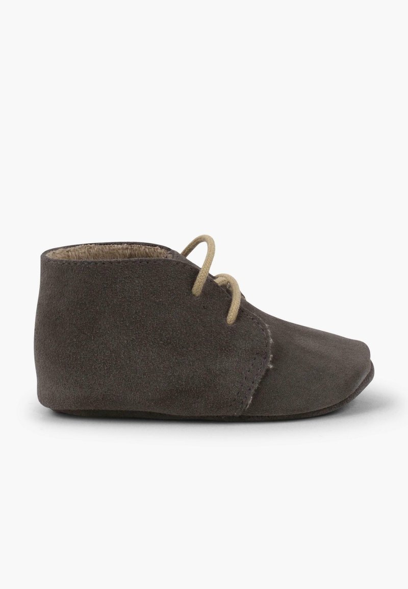 Chaussure bébé en daim marron foncé avec lacets beiges, semelle souple et design simple montant à la cheville sur fond blanc.