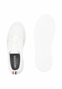 Weißer Sneaker mit perforiertem Außenmaterial, flacher weißer Sohle und schwarzem Innenfutter. Verfügt über einen kleinen roten und blauen Akzent an der Ferse.
