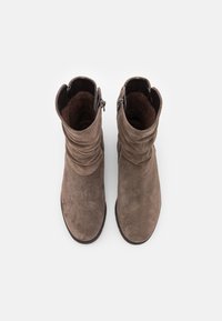 Brune semskede ankelstøvler med en slasket design, lynlås lukning på ydersiden, og struktureret indre foer. Gummisål for godt greb.