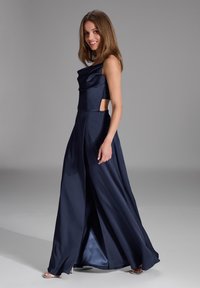 Abito in satin blu navy con bustino aderente, tagli laterali e gonna fluida. Presenta un collo arricciato e uno spacco alto fino alla coscia per un tocco in più.