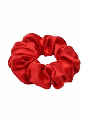 Rode satijnen scrunchie met zachte, geplooide stof die een cirkelvormige haaraccessoire vormt op een witte achtergrond.