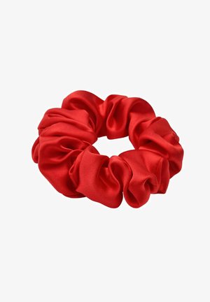 Rode satijnen scrunchie met zachte, geplooide stof die een cirkelvormige haaraccessoire vormt op een witte achtergrond.