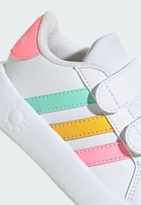 Biele tenisky s véčkom, s prúžkovanými akcentmi v mätovej zelenej, žltej a ružovej farbe. Hladká kožená konštrukcia s vypolstrovaným golierom.