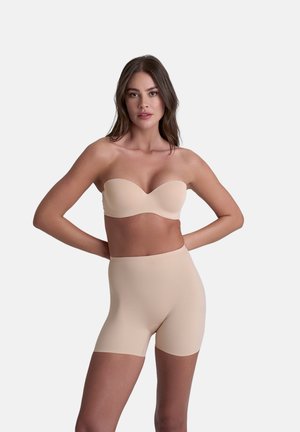 Beige strapless beha en hooggetailleerde short. Glad, rekbaar materiaal met een matte afwerking, ontworpen voor een naadloze uitstraling onder kleding.