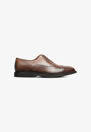 Chaussure habillée en cuir marron avec un bout rond, texture lisse, design à lacets, et une semelle extérieure contrastante noire. Détails de couture simples visibles.