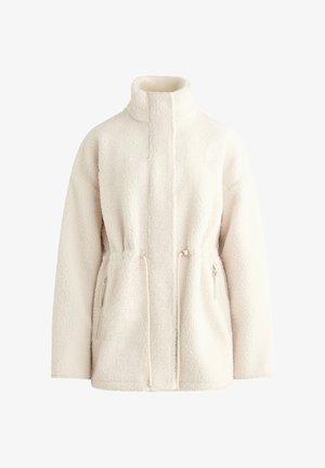 Jachetă din fleece de culoare crem, moale, cu guler înalt, mâneci lungi, fermoar frontal, talie cu șnur și buzunare laterale cu fermoar.