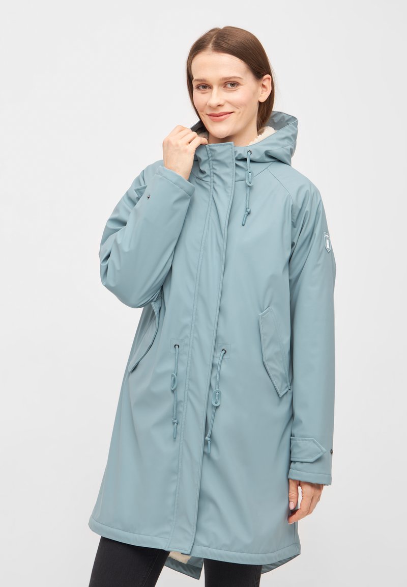 Abrigo impermeable de color azul claro con capucha, con cierre de cremallera, cintura ajustable con cordón, bolsillos laterales y un suave forro de piel cerca del cuello.
