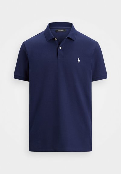 Granatowa koszulka polo z krótkim rękawem, z dwoma białymi guzikami oraz małym, białym haftowanym logo konia po lewej stronie klatki piersiowej.