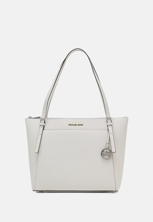 White leather Michael Kors tote bag with double shoulder straps, front pocket, and silver MK logo charm hanging from strap.