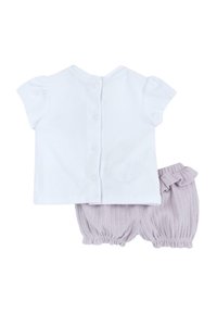 Top corto de manga corta blanco con botones en la parte posterior y pantalones cortos de bloomer de punto lavanda con cintura rizada y puños elásticos.