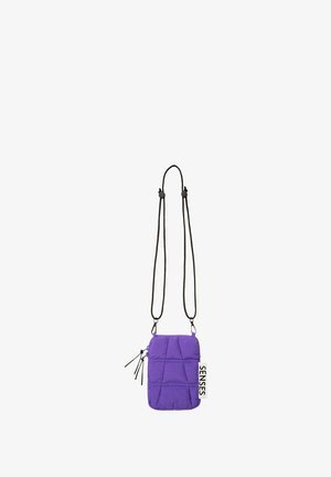 Purple quilted crossbody bag with black adjustable straps, zippered pocket, and a "SENSES" tag. Features a rectangular shape and smooth texture.