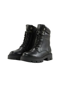 Botas de cuero negras con cordones en la parte delantera, cuello acolchado, cremallera lateral y suela de goma gruesa con surcos profundos para mayor tracción.