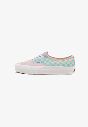 Baskets Vans avec un bout en toile rose et un motif en damier turquoise et beige sur le côté, avec des lacets blancs et une semelle en caoutchouc.