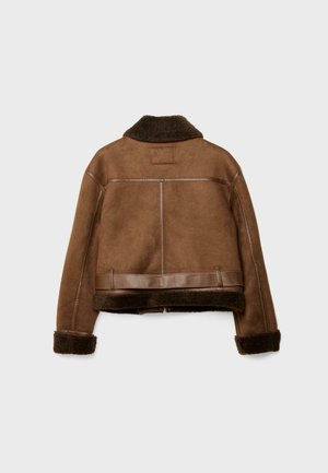 Veste en daim marron avec un col et des poignets en fourrure, présentant des accents en cuir et une silhouette courte et carrée. Vue de dos.