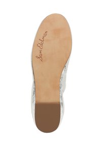 Semelle de chaussure métallique argentée avec une semelle intérieure en cuir beige lisse. Présente la marque "Sam Edelman" embossée en marron près de la zone du talon.