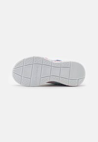 A Skechers sneaker talpa textúrált fehér gumiból készült, geometrikus mintázatú profillal és brandeléssel rendelkezik. A oldalain élénk színek láthatók.
