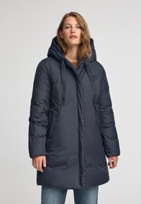 Marinblå lång pufferjacka med huva, med dragkedja, sidofickor och upphöjd logotypdetalj på bröstet. Slät, syntetisk tyg.