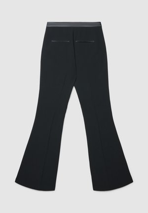 Pantaloni neri a zampa con una texture liscia, caratterizzati da una vita alta e due tasche posteriori. Design sartoriale per una vestibilità aderente.