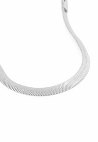 Silver metallkedja med en platt, flexibel design som har sammanlänkade delar och en subtil lyster. Närbild visar en slät yta.