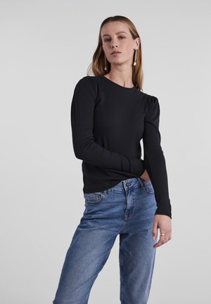 Svart, ribbete langermet topp med rund hals og rynket skulderdetalj, kombinert med blå denimjeans. Glatt tekstur, tettsittende design.