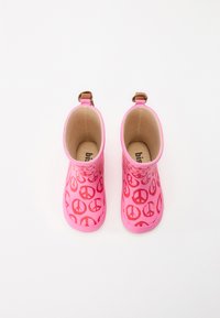 Ροζ ελαστικές μπότες βροχής που διαθέτουν επαναλαμβανόμενο μοτίβο με σύμβολο ειρήνης, με λεία υφή και καφέ λεπτομέρειες στις ιμάντες γύρω από τον αστράγαλο.