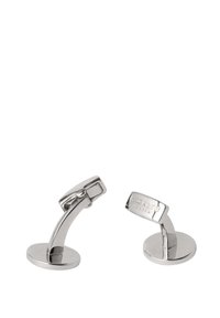 Metalne manžete s poliranim srebrnim finishingom, s zakrivljenim dizajnom i ravnim okruglim osnovama. Ugravirana oznaka na jednoj manžeti.