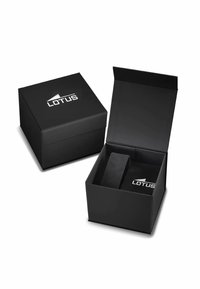 Schwarze quadratische Box mit Deckel, auf dem oben ein silbernes "LOTUS"-Logo zu sehen ist. Das Innere zeigt eine weiche, schwarze Polsterung zum Schutz.