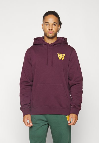 Maroon zip hoodie i mjukt tyg, med en kängeruficka och gult logo på bröstet. Huva med snoddar ingår.