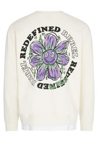 White long-sleeve shirt with large purple and green flower graphic and the words "REBEL REDEFINED" in black circling the flower on the back.