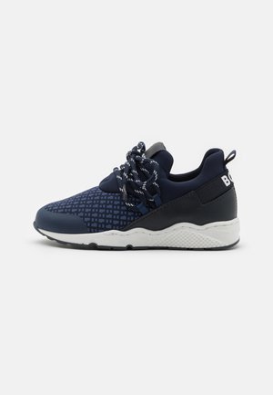 Marineblaue Sneaker mit einem gemusterten Mesh-Obermaterial, dicker weißer Sohle und schwarzen Akzenten. Verfügt über gewebte Schnürsenkel und eine Schlaufe an der Ferse.