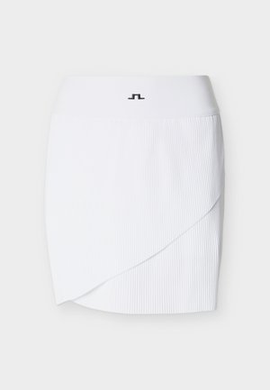 Valge voltidega seelik, millel on mähiskujundus ja lai vöökoht. Vööosa keskel on pisike must logo. Sile tekstuur.