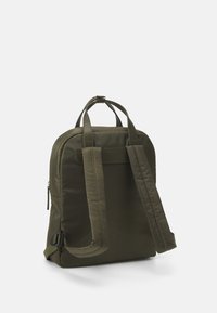 Mochila de nylon verde oscuro mostrada desde la parte trasera, con correas para los hombros ajustables y acolchadas, dos asas superiores y cierre de cremallera en el lado.